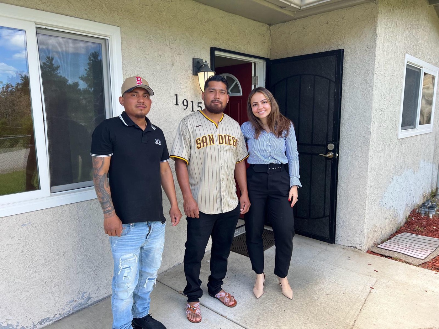 Paula with two clients at the front door of their house